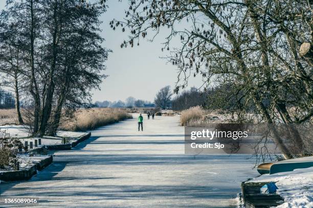 people ice skating in the weerribben wieden during a beautiful winter day - giethoorn stockfoto's en -beelden