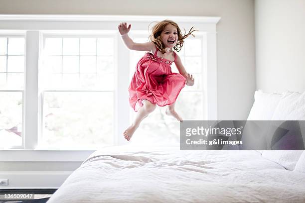 girl jumping on bed - day 4 stockfoto's en -beelden