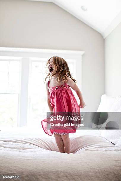 daughter jumping and screaming on bed - mädchen frech stock-fotos und bilder