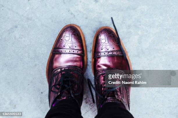 woman wearing metallic purple brogue shoes on concrete floor - flats footwear stock pictures, royalty-free photos & images