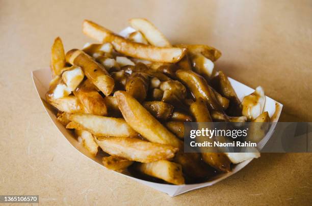 poutine served in a takeaway plate in canada - gravy stock pictures, royalty-free photos & images
