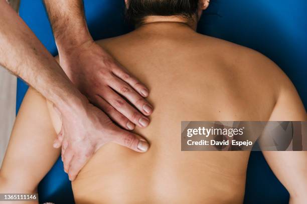 crop masseur tending topless patient - kinésithérapeute photos et images de collection