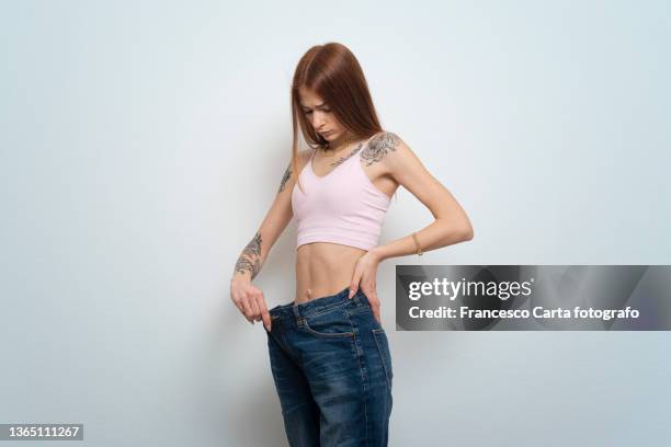 sad young woman losing weight - surdimensionné photos et images de collection