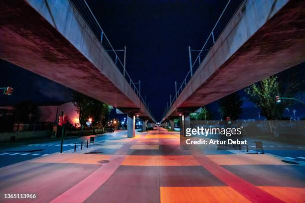 stunning futuristic architecture with elevated train at night. - diminishing perspective stock-fotos und bilder