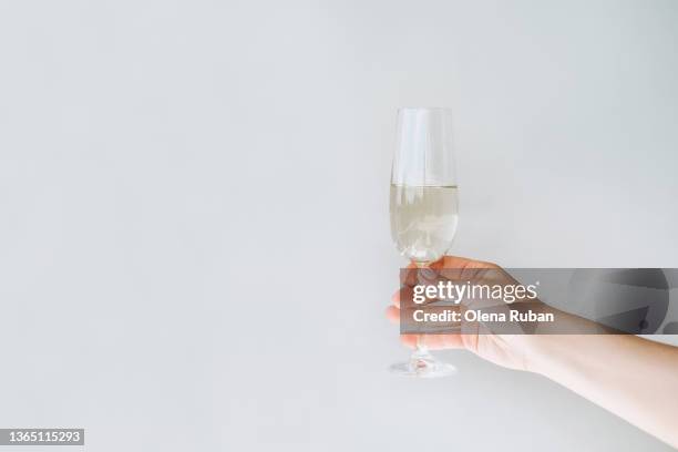 female hand holding champagne flute. - flute stock pictures, royalty-free photos & images