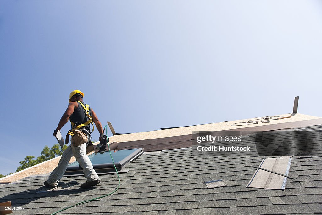 Roofer installing flashing on skylight
