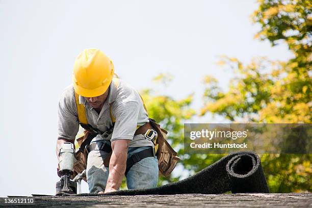 roofer working on shingling a new roof - dakdekker stockfoto's en -beelden