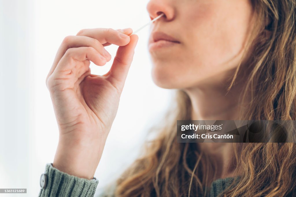 Woman doing a self covid antigen test at home