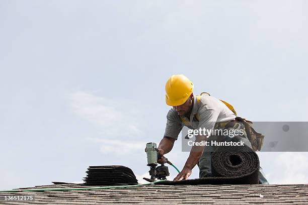 roofer working on shingling a new roof - dakdekker stockfoto's en -beelden