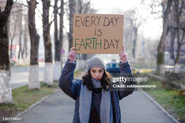 young activist holding sign protesting against climate change - climate activist 個照片及圖片檔