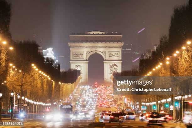 the arc de triomphe, by  night, paris - シャンゼリゼ通り ストックフォトと画像