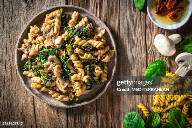 fusilli ai funghi alimento italiano vegano a base vegetale ricetta med - pasta agli spinaci foto e immagini stock