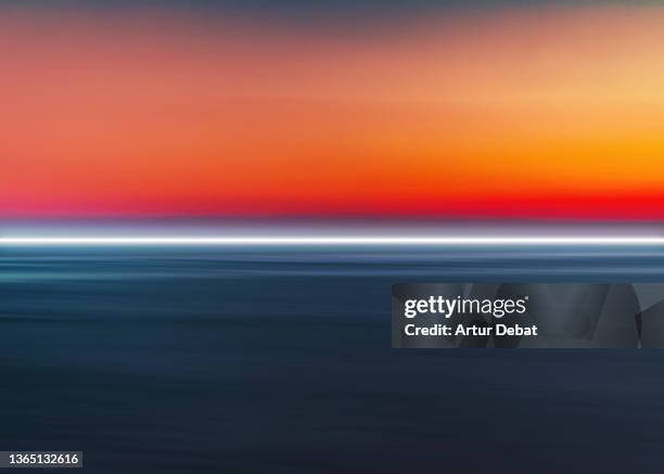 abstract picture of straight light trail flowing above the seascape at dusk. - landschaft rot stock-fotos und bilder