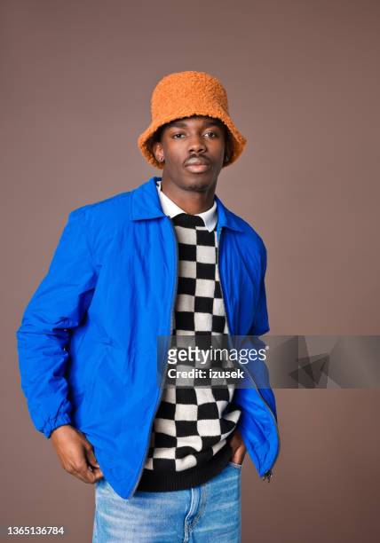 confident young man against brown background - checked trousers stock pictures, royalty-free photos & images