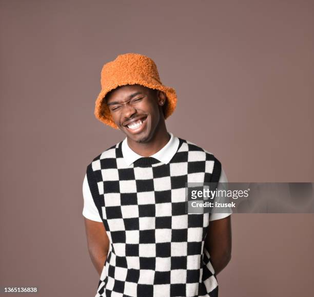 smiling young man against brown background - fashion orange colour stock pictures, royalty-free photos & images