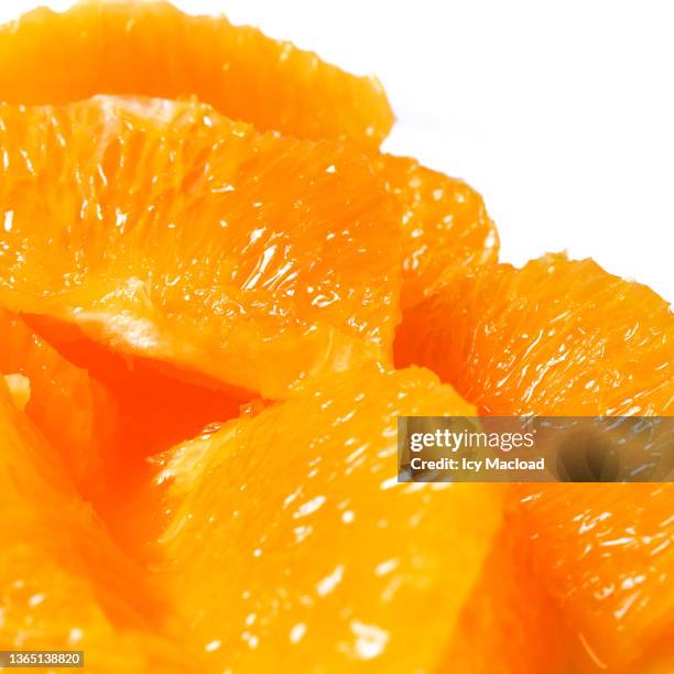 organic orange cut into pieces on white background - juicy stock pictures, royalty-free photos & images