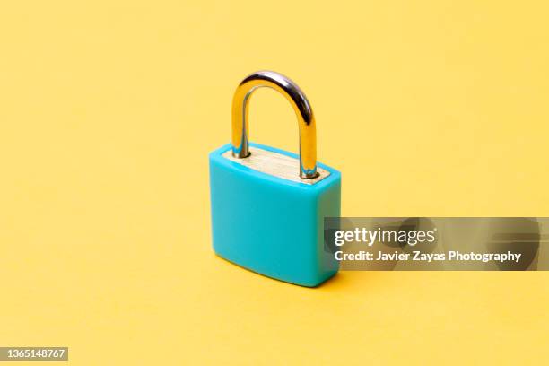 closed blue padlock on yellow background - password strength stock pictures, royalty-free photos & images