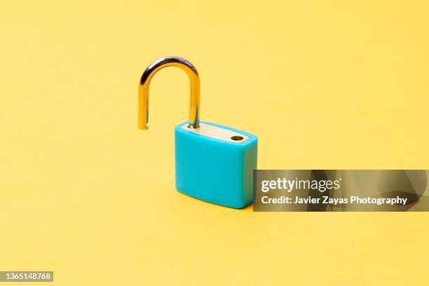 open blue padlock on yellow background - password strength stock pictures, royalty-free photos & images