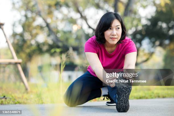 leg stretching exercise for flexibility reduce the risk of injury. woman doing legs stretching after running or jogging in a city park. - woman stretching ストックフォトと画像