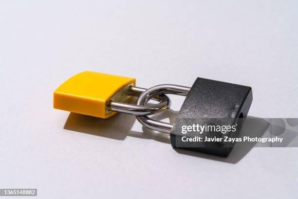 two padlocks interlocked on gray background - dedication icon stock pictures, royalty-free photos & images