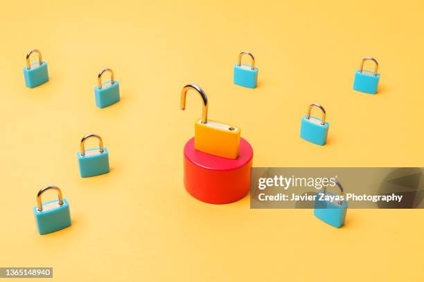 open yellow padlock surrounded by some blue closed padlocks - password strength stock pictures, royalty-free photos & images