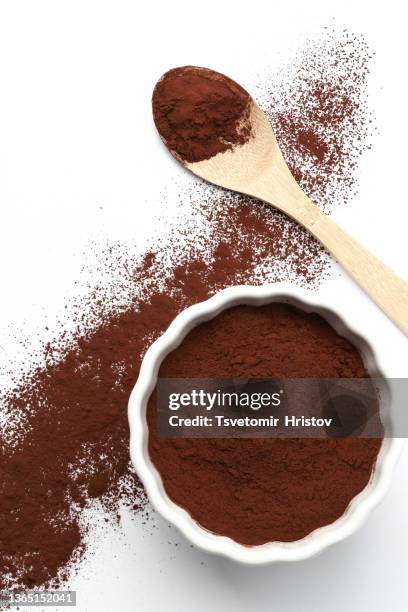 cocoa powder in white bowl and spoon isolated on white background. top view. flat lay. - coffee with chocolate stock-fotos und bilder