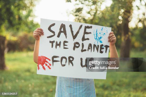 kid with posters protecting the planet. protest - atmosphere pollution stock pictures, royalty-free photos & images