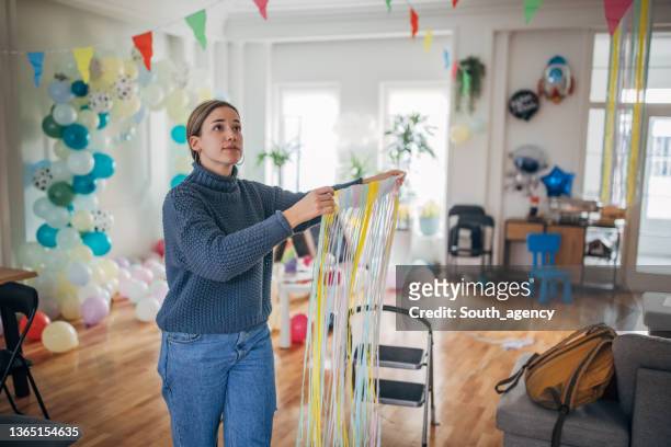 young woman decorater decorating room for birthday party - birthday decoration stock pictures, royalty-free photos & images