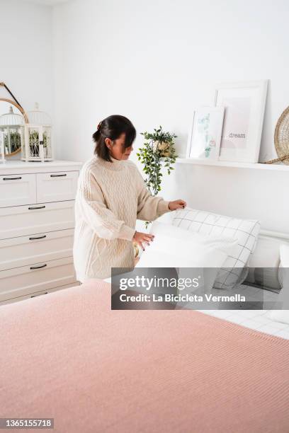 woman making the bed - making bed stockfoto's en -beelden