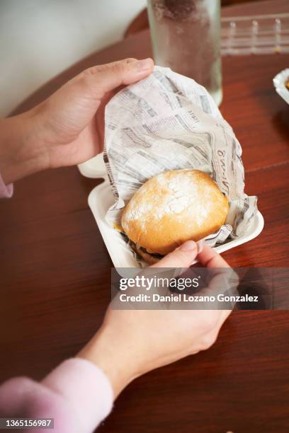 crop person unpacking takeaway burger - unwrapping burger stock pictures, royalty-free photos & images