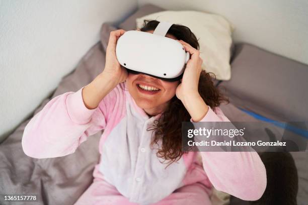 cheerful woman in vr glasses experiencing cyberspace at home - smart glasses eyewear foto e immagini stock