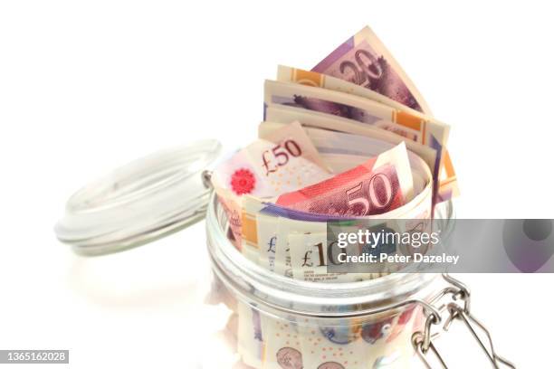 sterling pound notes in savings  jar - tax avoidance stock pictures, royalty-free photos & images