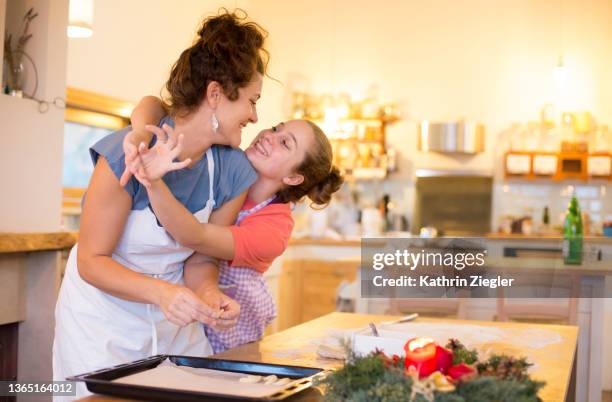 mother and daughter having fun, making christmas cookies together - traditional italian christmas stock pictures, royalty-free photos & images