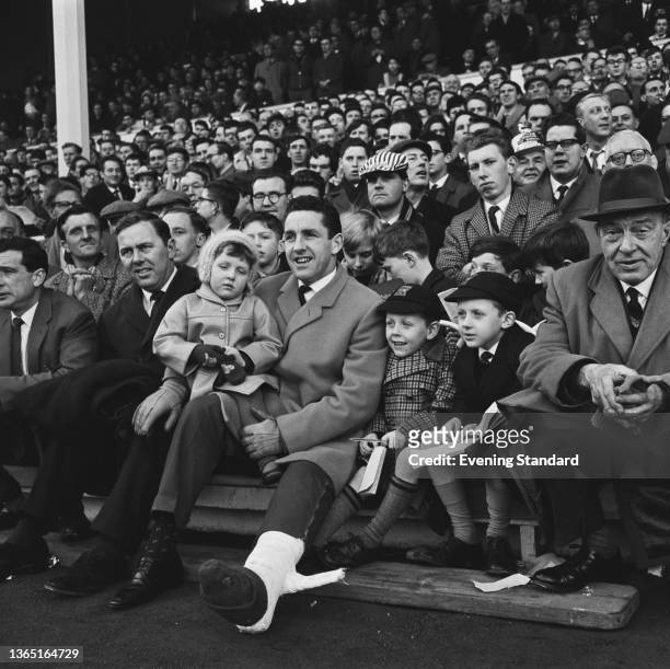 Scottish footballer Dave Mackay of Tottenham Hotspur FC watches his team play Chelsea at White Hart Lane in London, UK, accompanied by his children,...