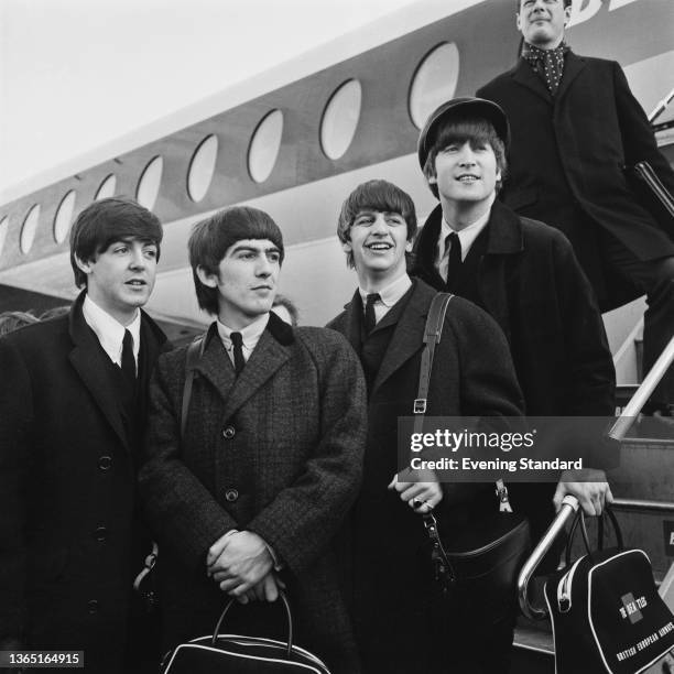 English rock band the Beatles arrive at London Airport in the UK, after a trip to Paris, France, 5th February 1964. From left to right, Paul...