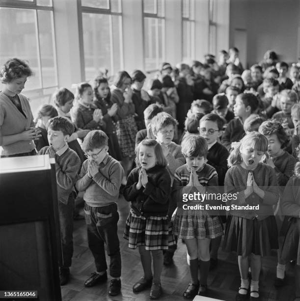 Children are led in prayer during assembly at Christ Church Church of England Primary School in Batten Street, Battersea, London, UK, 10th February...