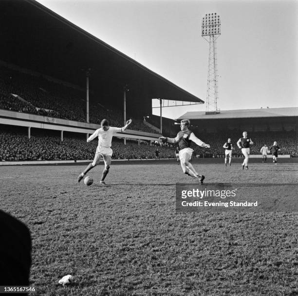 Footballers David Herd of Manchester United and Jack Burkett of West Ham United during a League Division One match at Upton Park in London, UK, 7th...