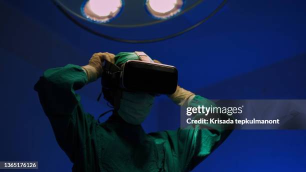 doctors in vr glasses performing surgery in hospital. - simulation stock pictures, royalty-free photos & images