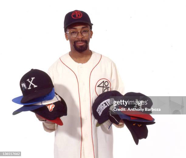 Portrait of American film director Spike Lee , as he holds an assortment of baseball caps, New York, New York, 1991. Dressed in baseball cap and...