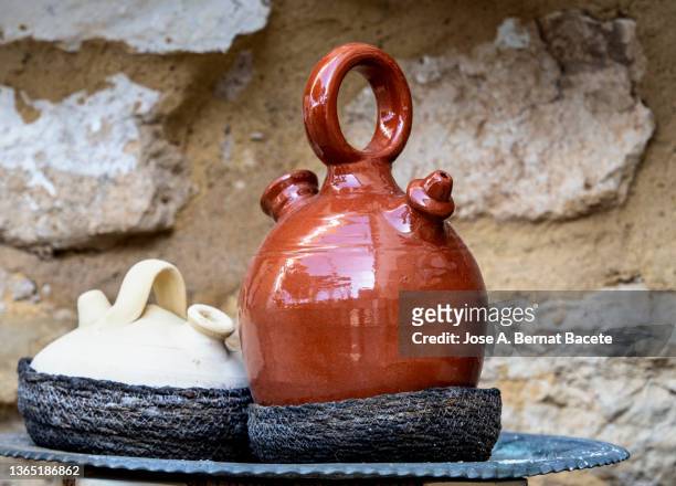 earthenware jar(spanish botijo)to keep fresh water at the entrance of a house in summer. - henkelkrug stock-fotos und bilder