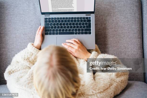 a woman writing a document on her laptop in her home office setup, seen from above - remote controlled stock pictures, royalty-free photos & images