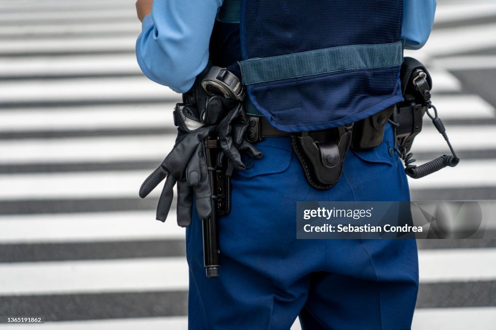 Midsection Of Police Woman Standing On Road