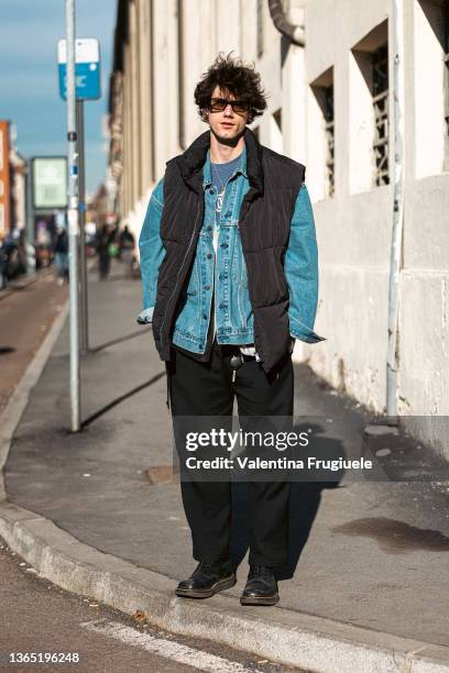 Guest wearing a sleeveless puffer jacket over a denim jacket is seen outside the David Catalán fashion show during Milan Men's Fashion Week -...