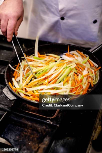 chef flash frying verdure - porro foto e immagini stock