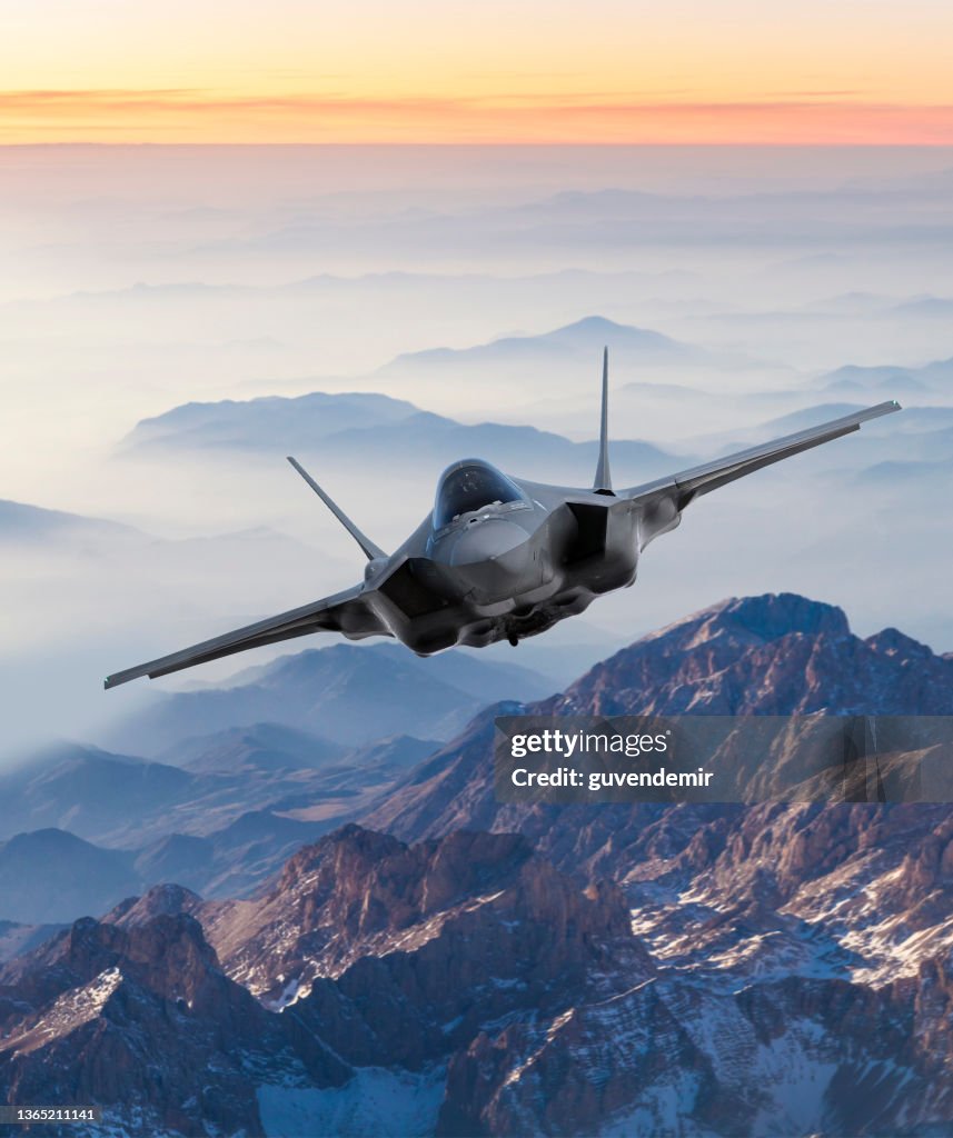 Fighter Jet flying over mountains at sunset