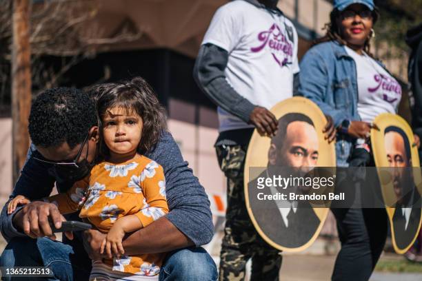 Man sits with his child during the 28th Annual Martin Luther King Jr. Grande Parade on January 17, 2022 in Houston, Texas. Community members,...