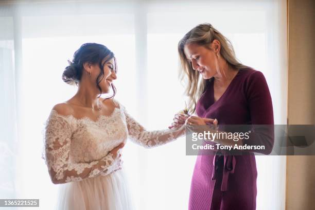 bridesmaid helping bride prepare for wedding - bride getting dressed stock pictures, royalty-free photos & images