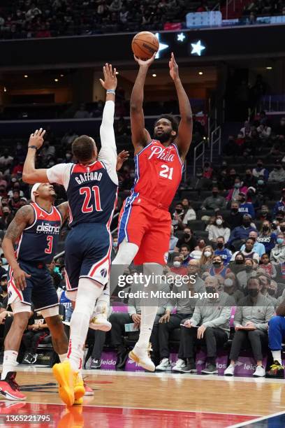 Joel Embiid of the Philadelphia 76ers takes a jump shot over Daniel Gafford of the Washington Wizards in the first quarter at the Capital One Arena...