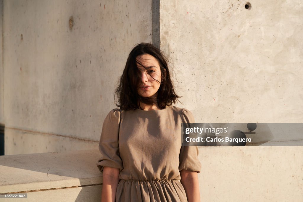 Serious portrait of pretty Caucasian young lady looking at camera.