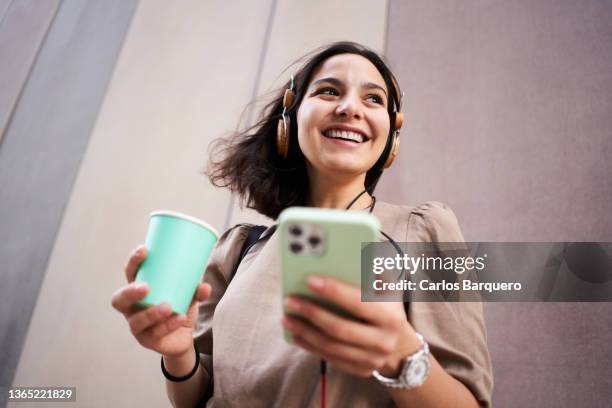 caucasian young lady hearing music from her phone. - low angle view portrait stock pictures, royalty-free photos & images